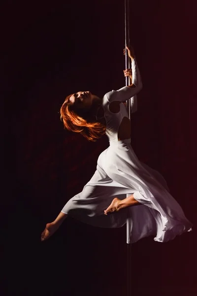 Adults learning pole at a weekly dance class in Bournemouth